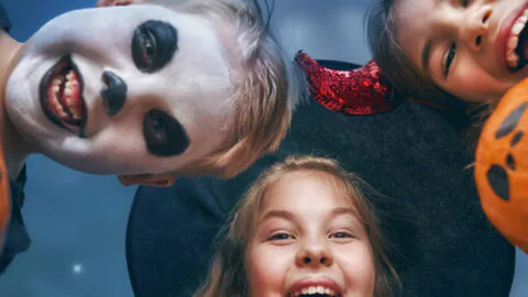 Happy children in Halloween costumes enjoying festive activities at family-friendly hotel. Perfect getaway for a spooky stay.