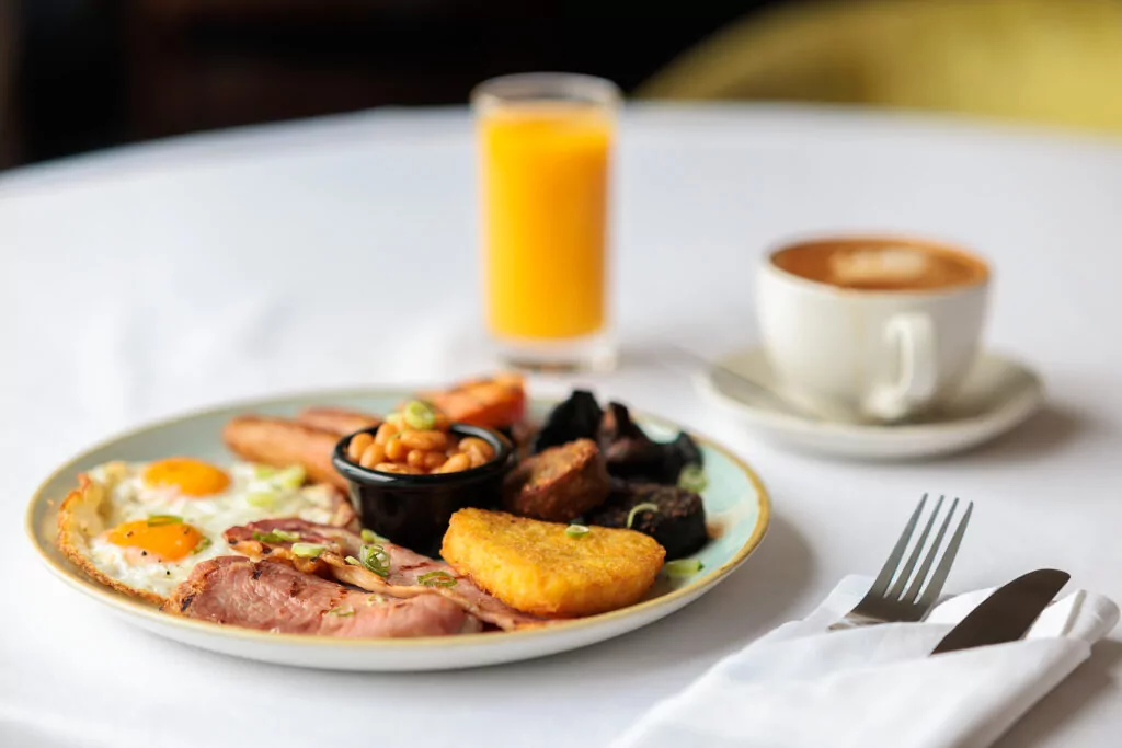 Full Irish breakfast with orange juice and coffee in background