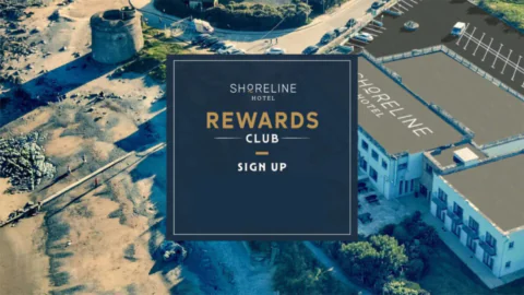 Coastal hotel aerial view, beachside amenities, lush landscape; perfect for relaxing getaways. Sign up for rewards.