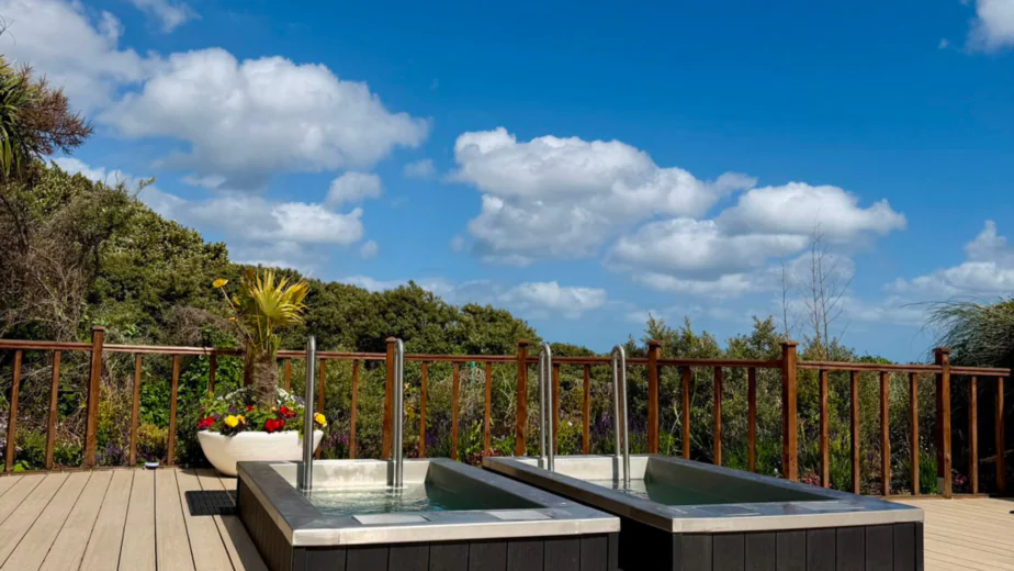 Relax in our hotel&rsquo;s outdoor hot tubs with scenic garden views under a clear blue sky, perfect for a tranquil getaway.