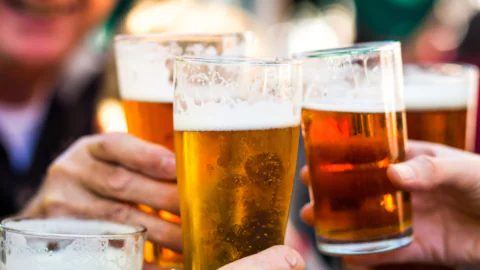 Guests enjoy pints of beer in a lively hotel garden, perfect for social gatherings and relaxation.