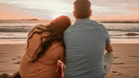 Couple enjoying a romantic beach sunset, perfect seaside escape with serene waves, ideal for relaxing getaways.
