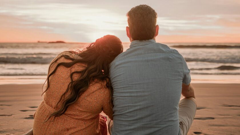Couple enjoying a romantic beach sunset, perfect seaside escape with serene waves, ideal for relaxing getaways.