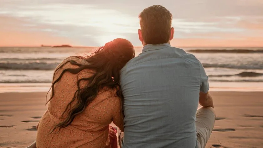 Couple enjoying a romantic beach sunset, perfect seaside escape with serene waves, ideal for relaxing getaways.